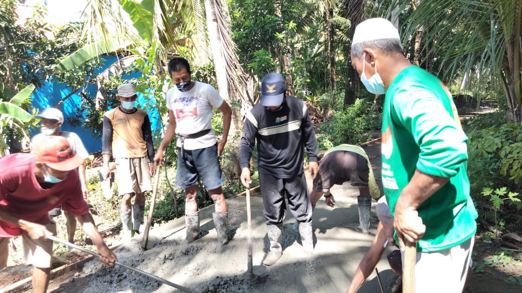 Warga Bojong meratakan material pengerasan jalan (foto : Lines Kulon Progo)